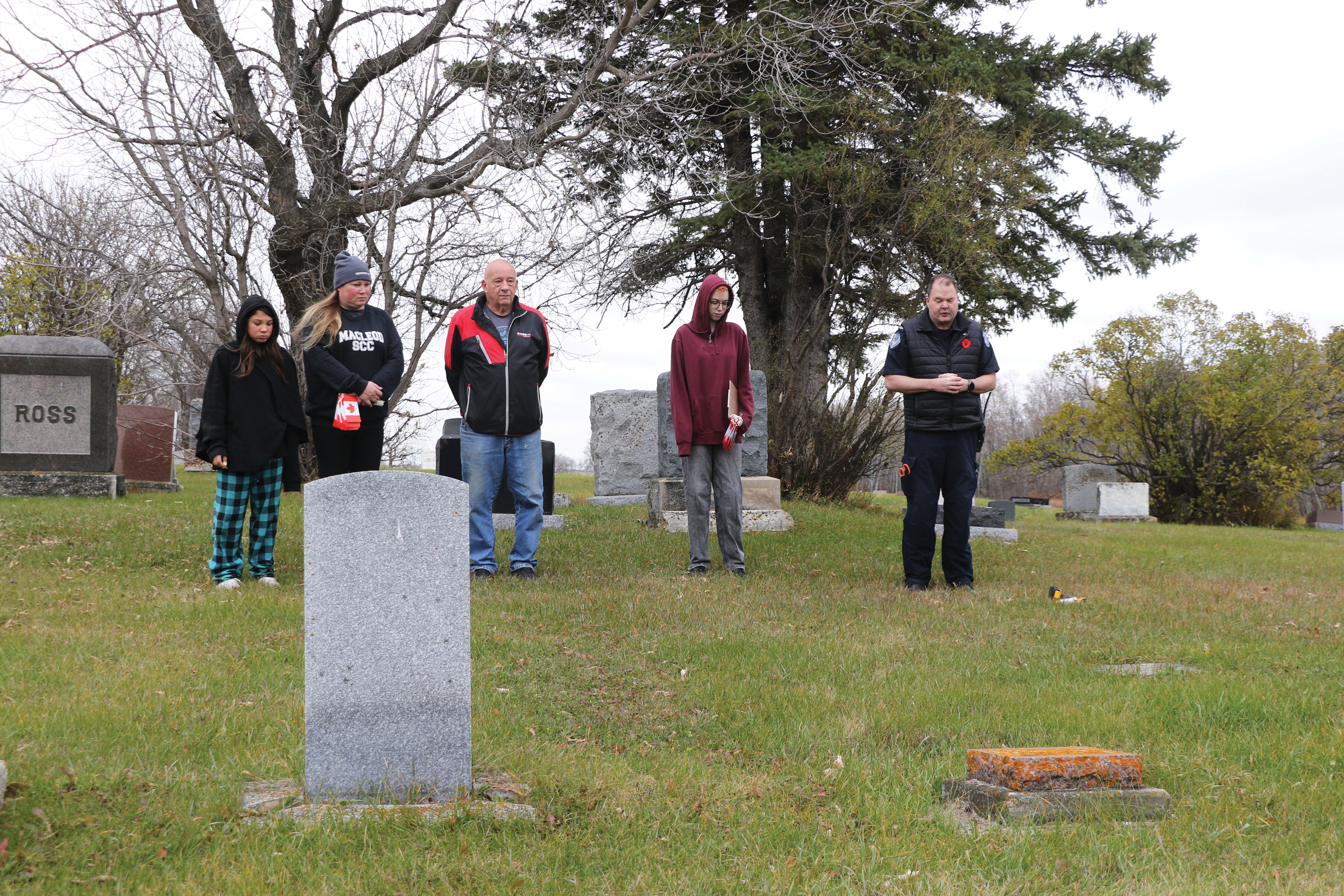 Saying a few words and a moment of silence before placing the flags. From left are Clara Dodsworth, Shannon Beckett, Brian Beckett, Ella Dodsworth Beckett, and Clay Leduc.