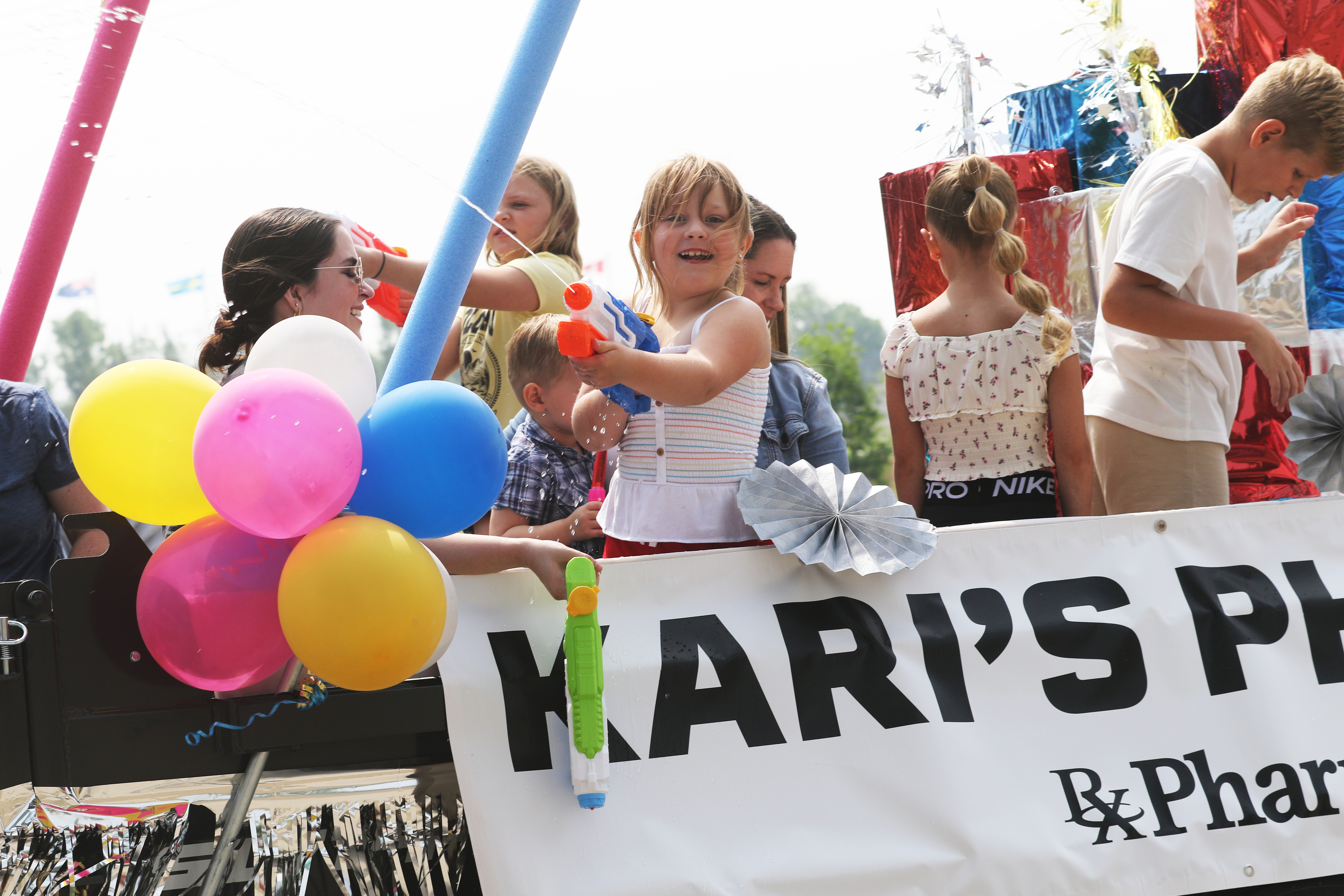 Children blast water guns off a float during last year’s Chamber parade.