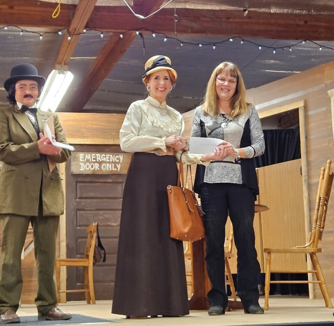 Actors Jocelyn Toms and Sandie Quennelle present a $2,000 dollar donation to Carlyle and District Food Bank representative Theresa Luedtke