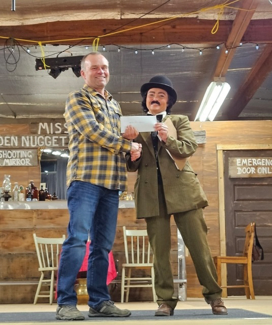 Redvers Fire Chief Brad Hutton accepting a $5,000 donation towards a new frontline fire truck presented by Jocelyn Toms.